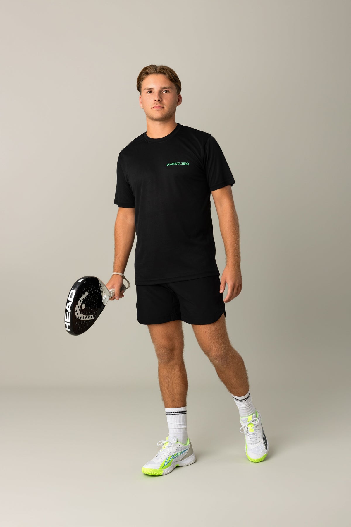 Padelspeler in zwart Cuarenta Zero shirt met een padelracket
